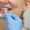 Close-up of patient showing her teeth while dentist choosing implants for her